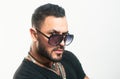 Handsome confident man. Serious guy posing in studio. Fashion young male model with sunglasses and confident face. Close Royalty Free Stock Photo