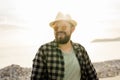 Handsome and confident. Outdoor portrait of smiling man wearing hat and sunglasses on beach. Holidays travel and summer Royalty Free Stock Photo