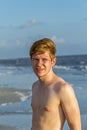 Handsome confident teenager in sunset at the beach