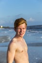 Handsome confident teenager in sunset at the beach