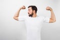 A handsome confident young man standing and showing big muscles on his hands. He is looking at one of them and very Royalty Free Stock Photo