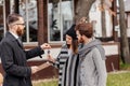 Friendly male real estate agent handing house key to a smiling young couple in office Royalty Free Stock Photo