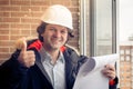 A handsome construction worker giving a thumbs-up sign. Authentic construction worker on actual construction site. Soft Royalty Free Stock Photo