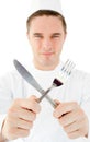 Handsome cook holding cutlery