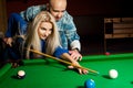 Handsome couple plays billiard on the pool table Royalty Free Stock Photo