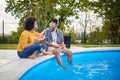 handsome couple by the pool havin fun, and eating watermelon