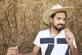 Handsome cowboy holding a pitch fork in stable