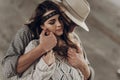 Handsome cowboy man in white hat touching cheek of beautiful boho gypsy woman with leather headband, face closeup portrait