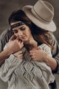 Handsome cowboy man in white hat touching cheek of beautiful boho gypsy woman with leather headband, face closeup portrait Royalty Free Stock Photo