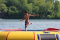 Handsome cute boy jumping at a water trampoline floating in a lake in Michigan during summer. Royalty Free Stock Photo