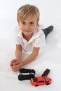 Handsome cute little boy lying behind a bunch of car toys and smiling sincerely Royalty Free Stock Photo