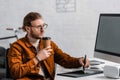 3d visualizer holding coffee to go and using graphics tablet near computer and vr headset on table