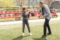 Handsome dad with his little cute daughter are having fun and playing American football on green grassy lawn Royalty Free Stock Photo