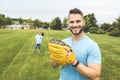 Handsome dad with his little cute sun are playing baseball on green grassy lawn Royalty Free Stock Photo