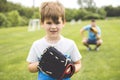 Handsome dad with his little cute sun are playing baseball on green grassy lawn Royalty Free Stock Photo