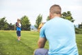 Handsome dad with his little cute sun are playing baseball on green grassy lawn Royalty Free Stock Photo