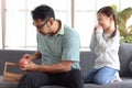 Handsome dad peeling apple for his daughter, cute little girl sitting on sofa in living room, waiting to eat apple, lovely family Royalty Free Stock Photo