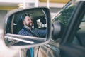 Handsome Dark-haired, bearded young elegant serious man drives a car. Royalty Free Stock Photo