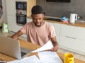 African man using laptop while caucasian girlfriend standing lonely at kitchen Royalty Free Stock Photo