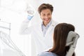 Handsome dentist greeting female patient sitting in chair