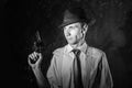 Handsome detective in hat holding a gun in the dark Royalty Free Stock Photo