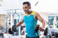 Handsome determined young man exercising with dumbbells in a mod Royalty Free Stock Photo