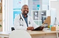 Handsome doctor in his office. African american doctor reading a patients chart. Mature medical professional reading Royalty Free Stock Photo