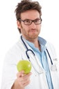 Handsome doctor holding green apple
