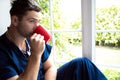 Handsome doctor or male nurse on break looking out of window Royalty Free Stock Photo