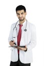 Handsome doctor writes on a clipboard in the studio Royalty Free Stock Photo
