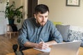 Handsome Eastern European man studying remotely at home during Corona virus quarantine Royalty Free Stock Photo