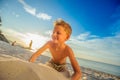 Handsome eight years boy on beach performs acrobatic sketches an