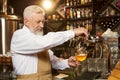 Barman pouring light beer in glass with beer tap. Royalty Free Stock Photo