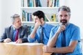 Handsome elderly businessman with beard and motivated team at office