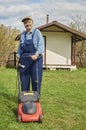 Handsome elderly man with a lawn mower Royalty Free Stock Photo