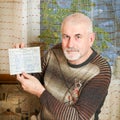 A handsome elderly man shows his work record.