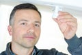 Handsome electrician changing light bulp Royalty Free Stock Photo
