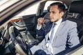 Attractive handsome elegant man in a business suit driving an expensive car Royalty Free Stock Photo