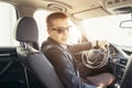 Attractive handsome elegant man in a business suit driving an expensive car Royalty Free Stock Photo