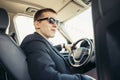 Attractive handsome elegant man in a business suit driving an expensive car Royalty Free Stock Photo