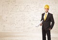 Handsome engineer calculating with hand drawn background
