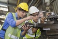 Handsome engineer in a factory. Professional technicians are holding a tablet to control work in industrial plants Royalty Free Stock Photo