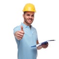 Handsome engineer makes thumbs up sign while holding blue files