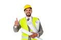 Handsome engineer showing thumb up while holding blueprints and smiling at camera Royalty Free Stock Photo
