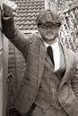 Handsome English gangster leaning on brick wall in back streets of birmingham