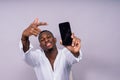 Handsome excited young african business man with mobile phone isolated over gray background Royalty Free Stock Photo