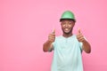 handsome excited young black man wearing a hard hat and holding a screwdriver feeling excited giving thumbs up gesture