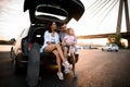 Handsome family are resting while sitting on the trunk of the car Royalty Free Stock Photo