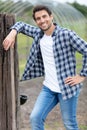 handsome farmer leaning on wooden fence