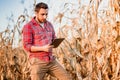handsome farmer using tablet for harvesting crops. Farming equipment and technology
